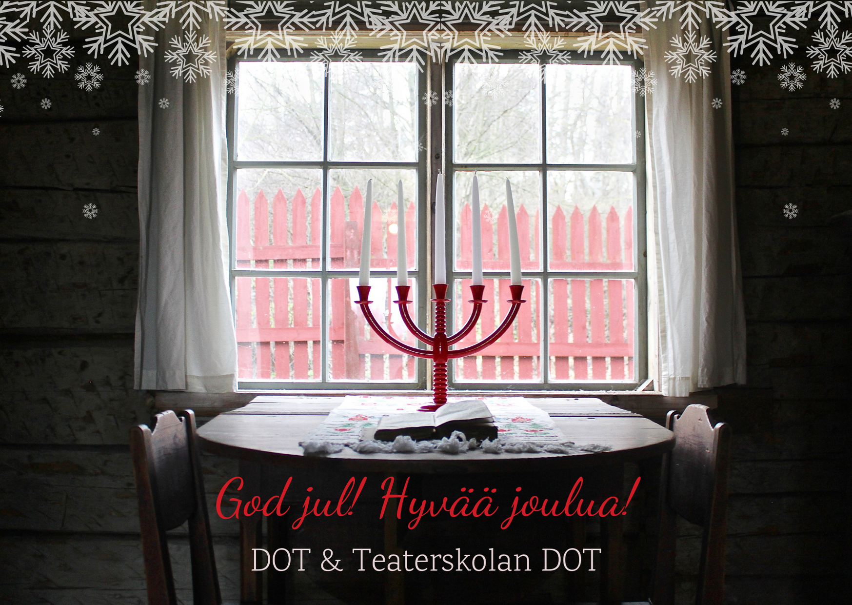 DOT önskar god jul! På bilden en ljusstake på ett bord vid ett fönster.